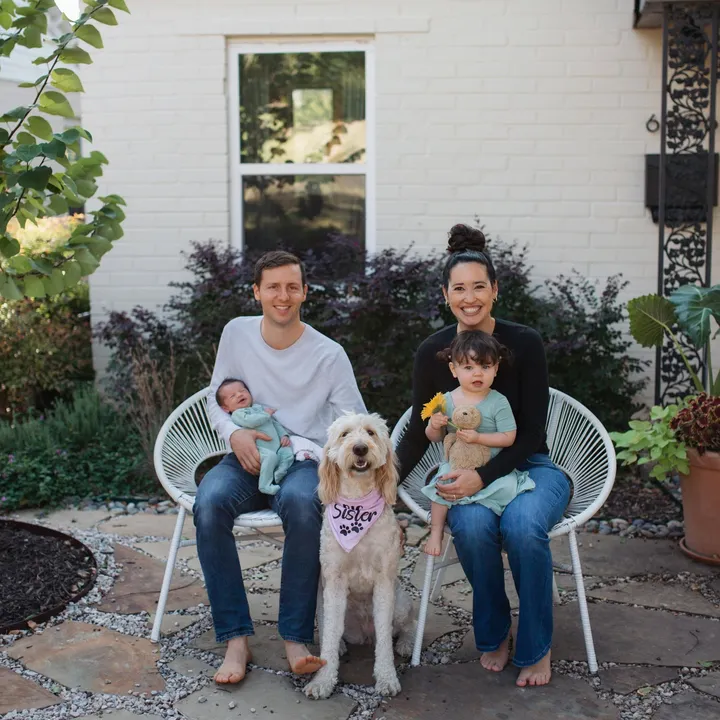 Erik and Melissa Larsen with their two daughters and their dog outside their home.