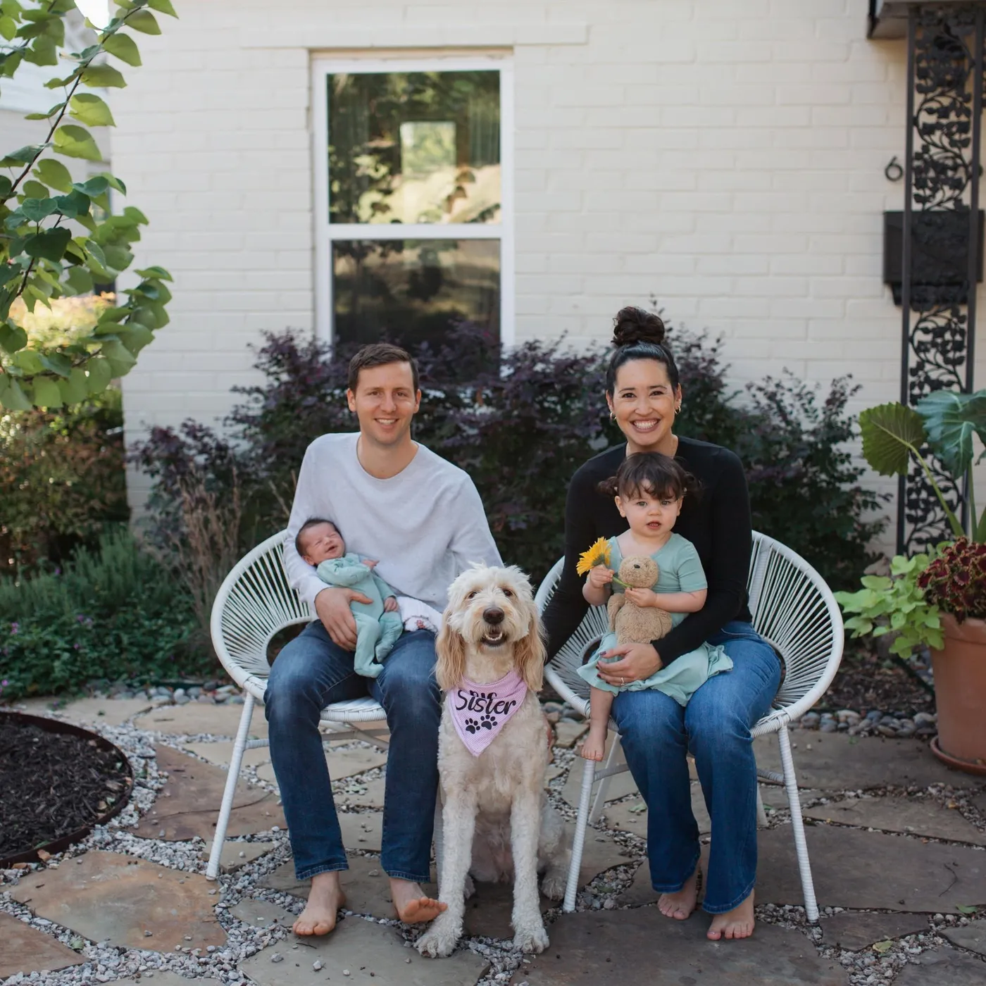Erik and Melissa Larsen with their two daughters and their dog outside their home.
